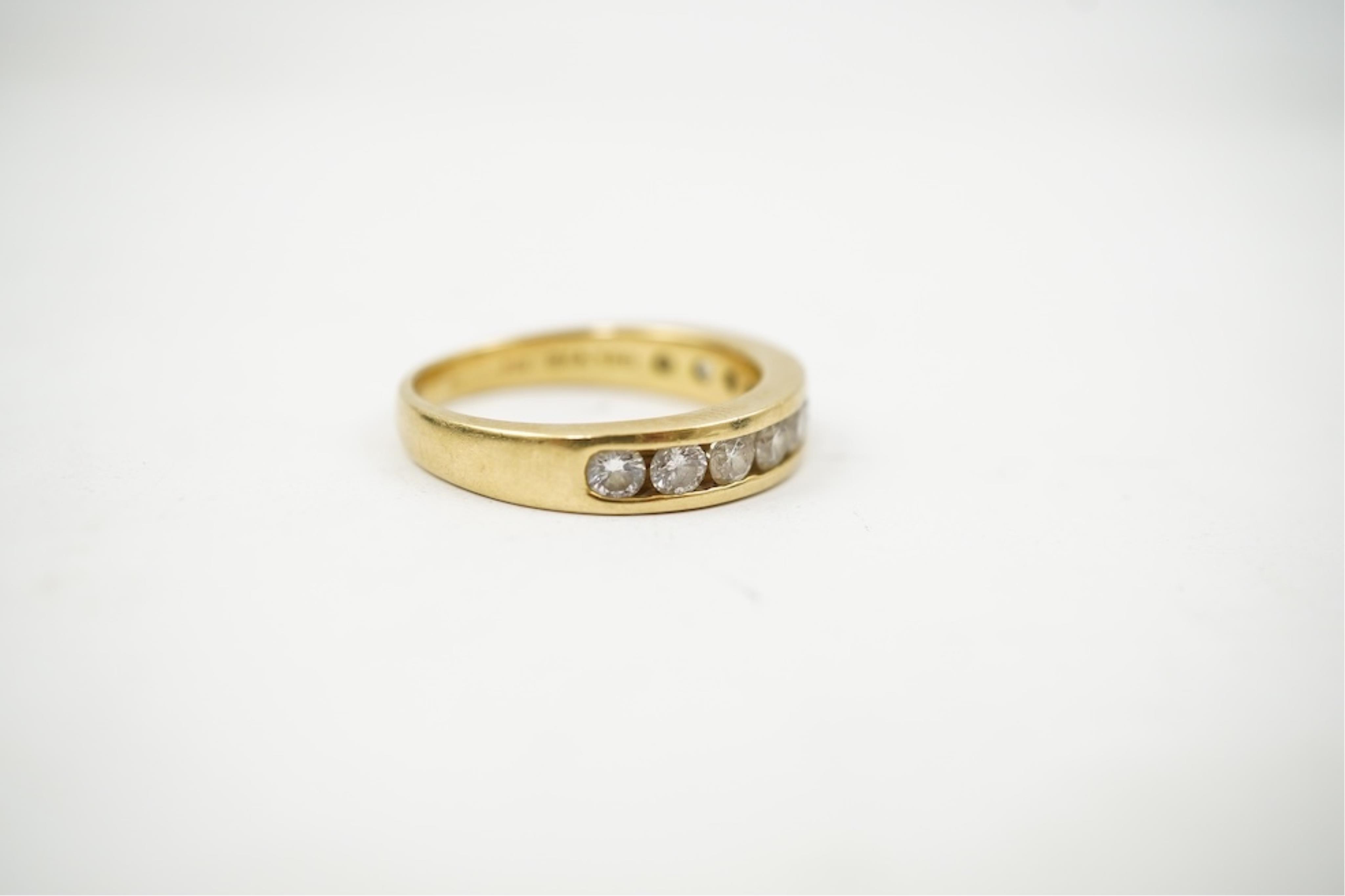 A modern 18ct gold and channel set graduated ten stone diamond set half eternity ring, size Q, gross weight 5.4 grams.